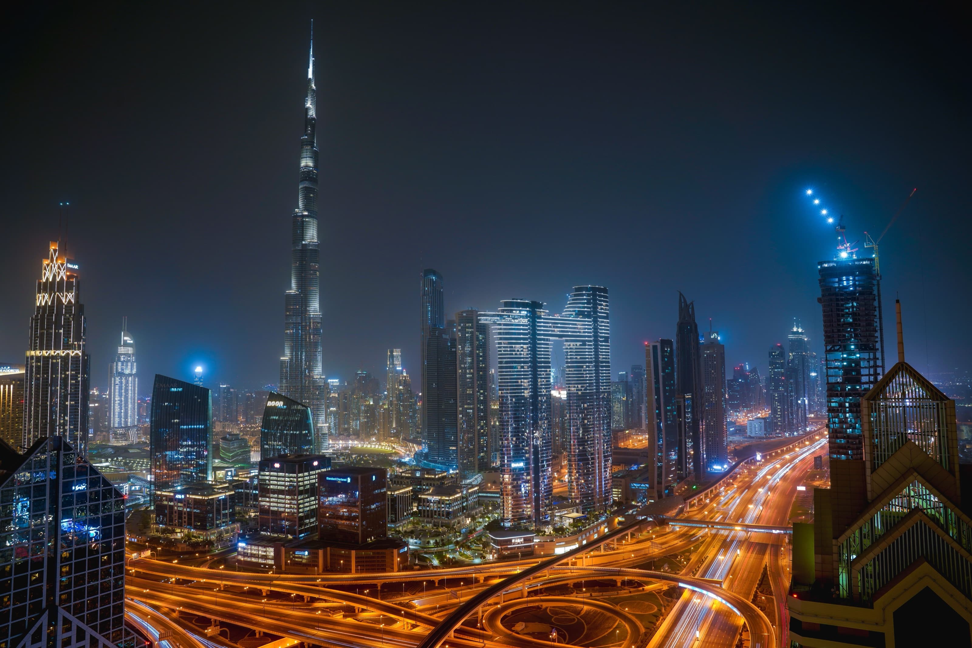 The Burj Khalifa towering over the illuminated Dubai skyline and roads at night